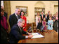 President George W. Bush, joined by the family of former President Lyndon Baines Johnson, signs H.R. 584 designating the U.S. Department of Education in Washington, D.C., as the Lyndon Baines Johnson Federal Building, Friday, March 23, 2007 in the Oval Office. White House photo by Eric Draper