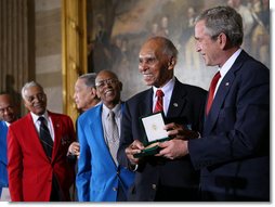 President George W. Bush presents the Congressional Gold Medal to Dr. Roscoe Brown Jr., during ceremonies honoring the Tuskegee Airmen Thursday, March 29, 2007, at the U.S. Capitol. Dr. Brown, Director of the Center for Urban Education Policy and University Professor at the Graduate School and University Center of the City University of New York, commanded the 100th Fighter Squadron of the 332 Fighter Group during World War II.  White House photo by Eric Draper