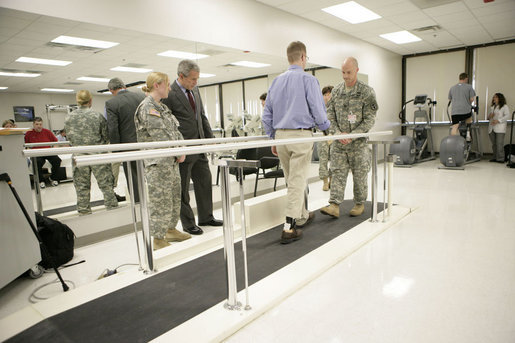 President George W. Bush watches U.S. Army 1st Lt. Scott Anthony Quilty of Francetown, N.H., demonstrate his walking abilities Friday, March 30, 2007, during a visit to Walter Reed Army Medical Center in Washington, D.C. Standing with the President is Lt. Quilty’s wife U.S. Army Capt. AnnMarie Dora Quilty. Lt. Quilty was later awarded the Purple Heart by President Bush. White House photo by Eric Draper