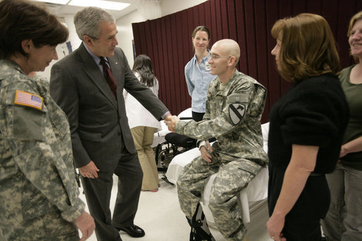 President George W. Bush talks with U.S. Army Pfc. Joshua Ryan Nielsen of Manvanola, Colo., and his family Friday, March 30, 2007, during a visit to Walter Reed Army Medical Center in Washington, D.C. White House photo by Eric Draper