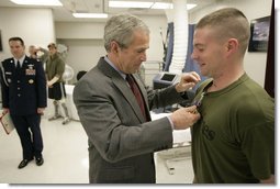 President George W. Bush presents the Purple Heart to U.S. Marine Lance Cpl. Joshua Ryan Bleill of Greenfield, Ind., during a visit Friday, March 30, 2007, to the Walter Reed Army Medical Center in Washington, D.C. Bleill is recovering from injuries sustained in Operation Iraqi Freedom.  White House photo by Eric Draper