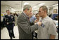 President George W. Bush presents the Purple Heart to U.S. Army Private First Class Casimir Domingo Werda of Novi, Mich., during a visit Friday, March 30, 2007, to the Walter Reed Army Medical Center in Washington, D.C. Werda is recovering from injuries sustained in Operation Iraqi Freedom. Werda's parents Floserfina Demano Werda and Gregory Lee Werda are seen background. White House photo by Eric Draper
