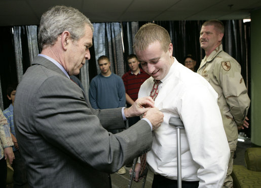 President George W. Bush presents the Purple Heart to U.S. Army Sgt. Bruce Dunlap of Kansas City, Mo., during a visit Friday, March 30, 2007, to the Walter Reed Army Medical Center in Washington, D.C. Dunlap was injured during convoy operations in southern Baghdad. White House photo by Eric Draper