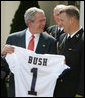 President George W. Bush accepts a jersey from co-captain Rob Caldwell of the U. S. Naval Academy football team, after President Bush presented the team with the Commander-In-Chief trophy in ceremonies in the Rose Garden at the White House, Monday, April 2, 2007. White House photo by Joyce Boghosian
