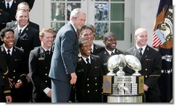 President George W. Bush poses for a photo with members of the U. S. Naval Academy football team and the Commander-In-Chief trophy he presented to the team in ceremonies in the Rose Garden at the White House, Monday, April 2, 2007. White House photo by Joyce N. Boghosian