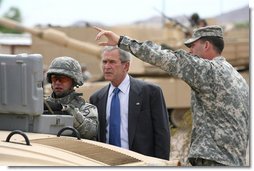 President George W. Bush watches as a soldier operates technical field equipment, joined by U.S. Army Captain Pat Armstrong, right, during President Bush’s visit to the U.S. Army National Training Center Wednesday, April 4, 2007, at Fort Irwin, Calif.  White House photo by Eric Draper