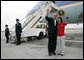 President George W. Bush and USA Freedom Corps greeter Hannah Locke wave to the press cameras, Wednesday, April 4, 2007 at Los Angeles International Airport. Locke, who was presented with the President’s Volunteer Service Award, is a volunteer with Jumpstart, a national program that pairs college students with at-risk preschool children to help them develop literacy, language and social skills. White House photo by Eric Draper