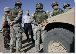 President George W. Bush stands amidst camouflaged troops Monday, April 9, 2007, during his tour of the U.S.-Mexico border in Yuma, Ariz. White House photo by Eric Draper
