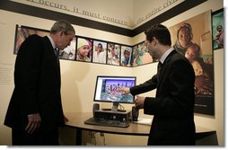 President George W. Bush watches a demonstration of Google Earth by Larry Swaider, Chief Information Officer for the U.S. Holocaust Memorial Museum, during his visit Wednesday, April 18, 2007. The President visited two exhibits and delivered remarks commemorating the Holocaust Days of Remembrance.  White House photo by Eric Draper