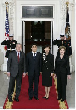 President George W. Bush and Mrs. Laura Bush stand for press photographs with Japanese Prime Minister Shinzo Abe and his wife Mrs. Akie Abe Thursday, April 26, 2007, as they arrive at the North Portico for a social dinner at the White House. White House photo by Eric Draper 