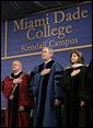 President George W. Bush stands for the national anthem onstage at Miami Dade College - Kendall Campus in Miami Saturday, April 28, 2007, before delivering the 2007 commencement address. With him are Miami Dade College President Dr. Eduardo Padron and Helen Aquirre Ferre, Chairman of the Board of Trustees at Miami Dade College. White House photo by Eric Draper