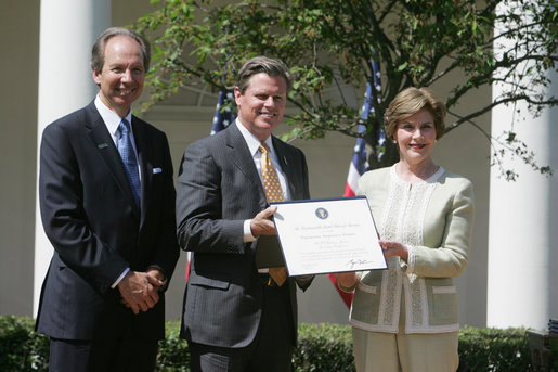 Mrs. Laura Bush presents a plaque to John McLaughlin, center, president and CEO of the USS Midway Museum in San Diego, Calif., and Scott McGaugh, marketing director of the museum, honoring them with a 2007 Preserve America Presidential Award in the Rose Garden at the White House Wednesday, May 9, 2007. White House photo by Joyce Boghosian