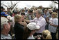 President George W. Bush reaches out to a woman as he tours a neighborhood Wednesday, May 9, 2007, in Greensburg, Kansas. The town of 1,600 people more than 90 percent of its homes and businesses in a deadly tornado last Friday, and the President toured the destruction and offered comfort to the community during his visit. White House photo by Eric Draper