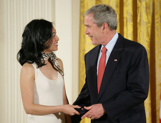 President George W. Bush congratulates Angela An of Washington, D.C., on presenting her the President’s Volunteer Service Award Thursday, May 10, 2007, in the East Room of the White House, in celebration of Asian Pacific American Heritage Month. White House photo by Eric Draper