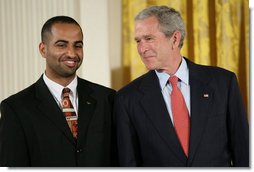 President George W. Bush speaks with award recipient Adeel Khan of Springfield, Va., student body president at Virginia Tech, on stage in the East Room of the White House, where Khan received the President’s Volunteer Service Award Thursday, May 10, 2007, in celebration of Asian Pacific American Heritage Month.  White House photo by Eric Draper