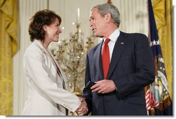 President George W. Bush congratulates military spouse Shannon Maxwell of Jacksonville, N.C., as Maxwell is presented with the President’s Volunteer Service Award Friday, May 11, 2007, in the East Room of the White House during a celebration of Military Spouse Day. White House photo by Eric Draper