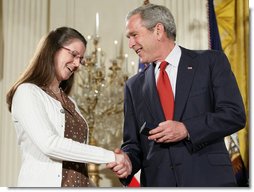 President George W. Bush congratulates military spouse Linda Port of Langley Air Force Base, Va., as she is presented with the President’s Volunteer Service Award Thursday, May 10, 2007, in the East Room of the White House during a celebration of Military Spouse Day. White House photo by Eric Draper