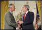 President George W. Bush congratulates military spouse Michael Winton of Wright-Patterson Air Force Base, Ohio, as Winton is presented with the President’s Volunteer Service Award Friday, May 11, 2007, in the East Room of the White House during a celebration of Military Spouse Day. White House photo by Eric Draper