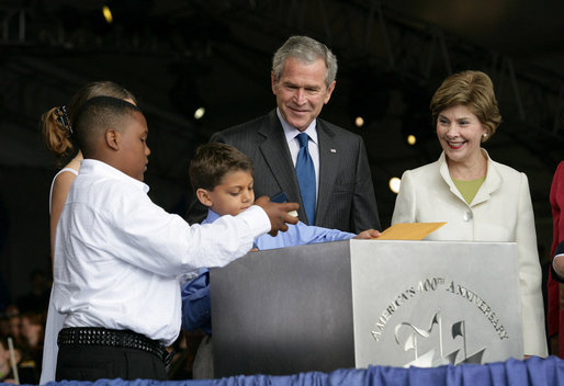 President George W. Bush and Mrs. Laura Bush have a little help onstage Sunday, May 13, 2007, placing items in a time capsule during the 400th anniversary celebration of Jamestown. White House photo by Eric Draper