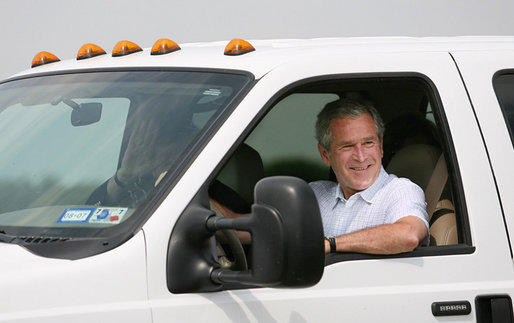 President George W. Bush smiles as NATO Secretary-General Jaap de Hoop Scheffer waves from the passenger seat Sunday after arriving at the Bush Ranch in Crawford, Texas. White House photo by Shealah Craighead