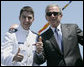 President George W. Bush, wearing the sunglasses of U.S. Coast Guard graduate Steven Matthew Volk, poses with Volk for a thumbs-up photo following the President’s address to the graduates Wednesday, May 23, 2007, at the U.S. Coast Guard Academy commencement in New London, Conn. White House photo by Joyce Boghosian