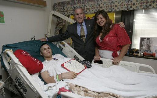 President George W. Bush stands with PFC. Arturo E. Weber and his cousin, Lisa, after awarding the Marine with a Purple Heart during a visit Friday, May 25, 2007, to the National Naval Medical Center in Bethesda, Md., where he is recovering from wounds received in Operation Iraqi Freedom. White House photo by Joyce N. Boghosian