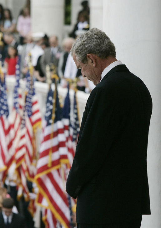 President George W. Bush bows his head during the reading of the invocation at the Memorial Day ceremony Monday, May 28, 2007, at Arlington National Cemetery in Arlington, Va. Addressing the gathered audience President Bush said, “The greatest memorial to our fallen troops cannot be found in the words we say or the places we gather. The more lasting tribute is all around us—a country where citizens have the right to worship as they want, to march for what they believe, and to say what they think.” White House photo by Joyce Boghosian