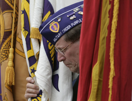 A flag bearer for the Military Order of the Purple Heart bows his head during the Memorial Day commemoration ceremony Monday, May 28, 2007, at Arlington National Cemetery in Arlington, Va. White House photo by Joyce Boghosian