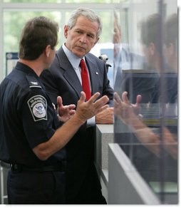 President George W. Bush listens to Ty Bowers, Assistant Director of U.S. Customs and Border Protection, as he demonstrate how people are screened at primary and secondary locations Tuesday, May 29, 2007, during a tour of the Federal Law Enforcement Training Center in Glynco, Ga.  White House photo by Eric Draper