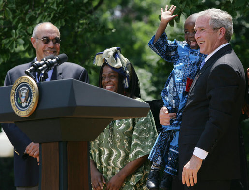 President George W. Bush holds Baron Mosima Loyiso Tantoh in the Rose Garden of the White House Wednesday, May 30, 2007, after delivering a statement on PEPFAR, the President's Emergency Plan for AIDS Relief. With them are the boy's mother, Kunene Tantoh, representing Mothers to Mothers, which provides treatment and support services for HIV-positive mothers in South Africa, and Dr. Jean "Bill" Pape, internationally recognized for his work with infectious diseases. White House photo by Chris Greenberg