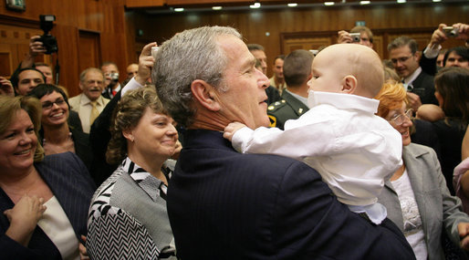 President George W. Bush holds the baby of a U.S. Embassy staff member in Prague Tuesday, June 5, 2007, during a visit to the embassy in the Czech Republic before leaving for Germany to attend the G8 Summit. White House photo by Eric Draper
