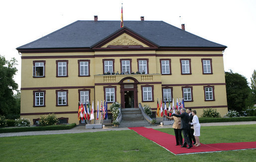 President George W. Bush and Mrs. Laura Bush and German Chancellor Angela Merkel and husband, Dr. Joachim Sauer, wave to the media prior to dinner for the G8 leaders and their spouses Wednesday, June 6, 2007 at Hohen Luckow Estate in Hohen Luckow, Germany. White House photo by Eric Draper