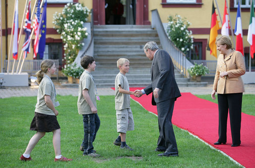 President George W. Bush reaches out to youngsters who were on hand to greet him upon his arrival Wednesday night at the Hohen Luckow Estate in Hohen Luckow, Germany. The President and Mrs. Laura Bush joined other G8 leaders and their spouses for a dinner hosted by Germany's Chancellor Angela Merkel and her husband, Dr. Joachim Sauer. White House photo by Eric Draper