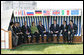 Leaders of the G8 sit on a canopied bench after meeting with Junior G8 Student Leaders Thursday, June 7, 2007, in Heiligendamm, Germany. From left, and under their respective country flags, are: Prime Minister Shinzo Abe of Japan; Prime Minister Stephen Harper of Canada; President Nicolas Sarkozy of France; Chancellor Angela Merkel of Germany, President George W. Bush of the United States; Prime Minister Tony Blair of the United Kingdom; Prime Minister Romano Prodi of Italy, and Jose Manuel Barroso, President of the European Commission. White House photo by Eric Draper