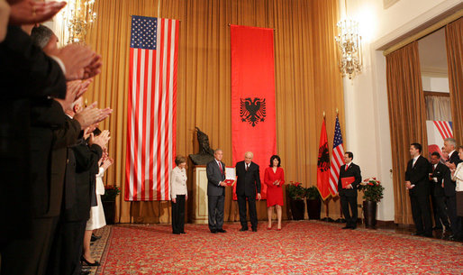 President George W. Bush receives the Order of the National Flag Award from President Alfred Moisiu during an arrival ceremony Sunday, June 10, 2007, in Tirana, Albania, as Mrs. Laura Bush and Ms. Mirela Moisiu look on. The visit by the President and Mrs. Bush marked the first to Albania by a sitting U.S. president. White House photo by Chris Greenberg