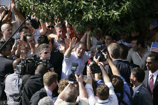 President George W. Bush waves as he's surrounded by townspeople and media Sunday, June 10, 2007, during his visit to Fushe Kruje, Albania. White House photo by Shealah Craighead