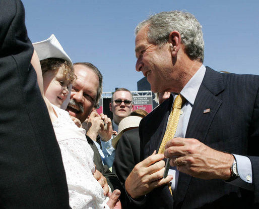 President George W. Bush greets a young child as he signs autographs following his speech Tuesday, June 12, 2007, at the dedication ceremony for the Victims of Communism Memorial in Washington, D.C. White House photo by Joyce N. Boghosian