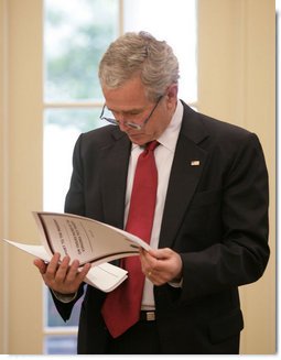 President George W. Bush reads the Report to the President on Issues Raised by the Virginia Tech Tragedy in the Oval Office Wednesday, June 13, 2007. The report, presented to President Bush Wednesday afternoon, was compiled by the departments of Justice, Health and Human Services and Education in response to the tragic shooting rampage at Virginia Tech April 16, 2007 in Blacksburg, Va.  White House photo by Eric Draper