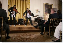 President George W. Bush and guests watch violinists Tourie and Damien Escobar of Nuttin’ But Stringz, as they perform Friday, June 22, 2007 in the East Room of the White House, in celebration of Black Music Month. White House photo by Eric Draper