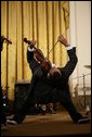 Violinist Tourie Escobar arches back almost to the floor as he performs with his brother Damein for President George W. Bush and guests Friday, June 22, 2007 in the East Room of the White House, in celebration of Black Music Month. White House photo by Eric Draper