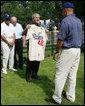 President George W. Bush holds up a commemorative baseball jersey with Jackie Robinson's number 42 presented to him by players from Robinson's playing era at the White House Tee Ball Game Sunday, July 15, 2007. Tee Ball players wore the number 42 to celebrate the legacy of Jackie Robinson. More about Tee Ball on the South Lawn. White House photo by Chris Greenberg