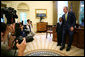 President George W. Bush and Ezekiel “Zeek” Taylor, 8, of Durham, N.C., the 2007 March of Dimes National Ambassador, pose for photographers during their meeting in the Oval Office at the White House Monday, July 30, 2007. White House photo by Eric Draper