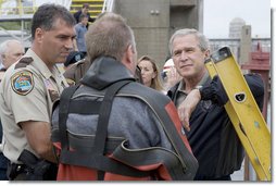 President George W. Bush listens to a search and rescue diver describe the scene in the Mississippi River during his visit to the Interstate 35W bridge collapse in Minneapolis, Saturday, Aug. 4, 2007. President Bush praised the work of first responders, local authorities and investigators in their response to the tragic bridge collapse. White House photo by Chris Greenberg