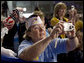 Audience members take photos of President George W. Bush, as he delivers his remarks Wednesday, Aug. 22, 2007, to the Veterans of Foreign Wars National Convention in Kansas City, Mo. White House photo by Chris Greenberg