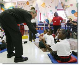 President George W. Bush reaches down to greet a student at the Dr. Martin Luther King Jr. Charter School for Science and Technology Wednesday, Aug. 29, 2007, in New Orleans, during his visit to New Orleans and the Gulf Coast region on the second anniversary of Hurricane Katrina. White House photo by Shealah Craighead