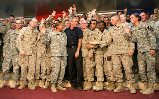 President George W. Bush greets troops on stage after his remarks at Al Asad Airbase, Al Anbar Province, Iraq, Monday, September 3, 2007. White House photo by Eric Draper