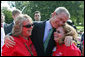 President George W. Bush hugs Theresa Luna of Oxnard, Calif., left, and Debbie Parrish of LaSalle, Colo., during an event for military support organizations Tuesday, Sept. 18, 2007, on the South Lawn. Ms. Luna's son, Pfc. Kevin Luna, died in June 2005 while serving with the U.S. Army in Iraq. Ms. Parrish's son, Pfc. Victor Parrish, is serving with the U.S. Marines in Iraq. White House photo by Chris Greenberg
