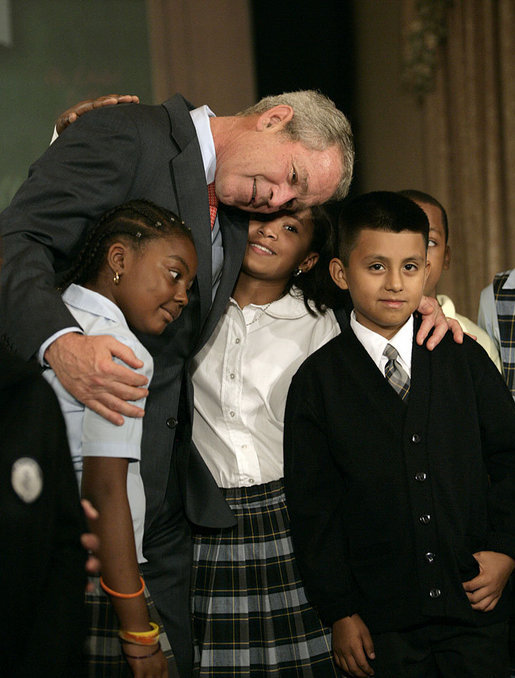 President George W. Bush hugs students from New York Public School 76 as he makes a statement to the press about No Child Left Behind Wednesday, Sept. 26, 2007, in New York. "Last week the school system here in New York City received the Broad Prize for Urban Education. This is one of the most prestigious education prizes in the country," said the President. "The award is given every year to large urban school districts that have shown the greatest overall performance and improvement in student achievement, while narrowing the achievement gap amongst poor and minority students." White House photo by Eric Draper