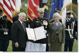 Outgoing Joint Chiefs of Staff Chairman U.S. Marine General Peter Pace, joined by his wife, Lynne Pace, right, receives his official certificate of retirement from the U.S. Marine Corps from U.S. Secretary of Defense Robert Gates, during the Armed Forces farewell tribute in honor of General Pace and the Armed Forces hail in honor of the new Joint Chiefs of Staff Chairman Navy Admiral Michael Mullen, Monday, October 1, 2007 at Fort Myer, Virginia. White House photo by Eric Draper