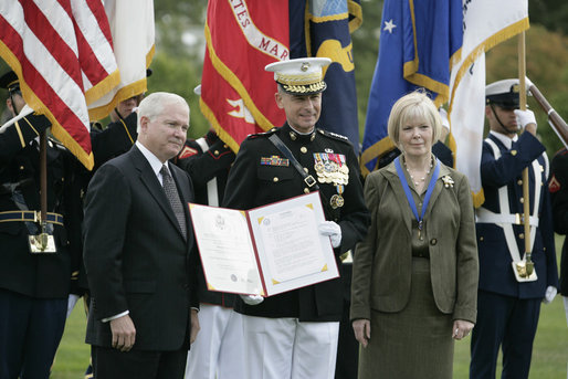Outgoing Joint Chiefs of Staff Chairman U.S. Marine General Peter Pace, joined by his wife, Lynne Pace, right, receives his official certificate of retirement from the U.S. Marine Corps from U.S. Secretary of Defense Robert Gates, during the Armed Forces farewell tribute in honor of General Pace and the Armed Forces hail in honor of the new Joint Chiefs of Staff Chairman Navy Admiral Michael Mullen, Monday, October 1, 2007 at Fort Myer, Virginia. White House photo by Eric Draper